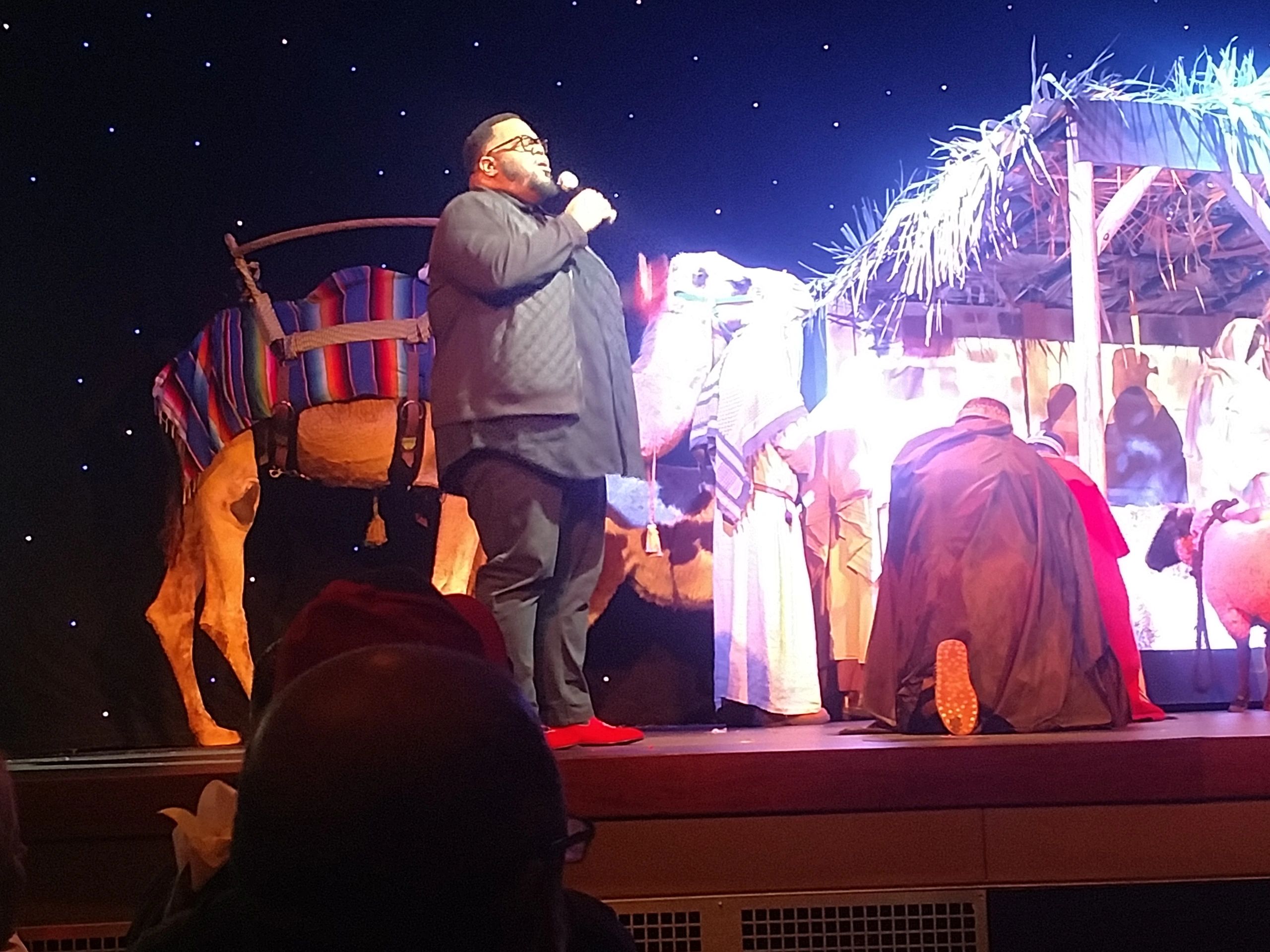 Singer, actors and camels on stage during live audience stage production at a church