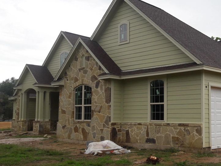 A house with stone and wood siding at the front elevation. The stone is in different shades of brown