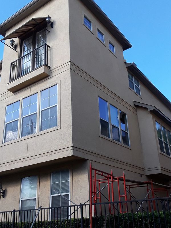 Townhome before stucco facade remodel. Stucco is dirty and there are some ledge lines. Right view.