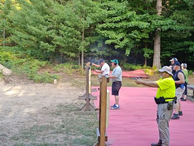 People practicing target shooting outdoors.