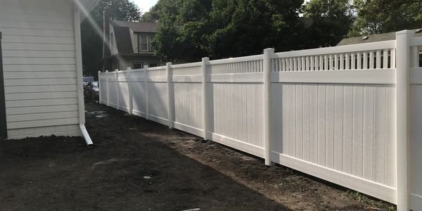 New white vinyl fence along a house.