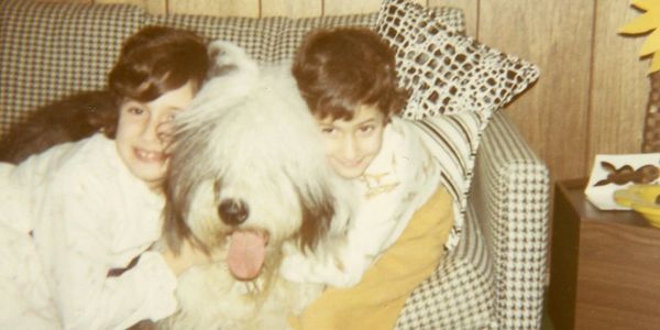 Two children (my brother and me) hugging an Old English Sheepdog (Patches)