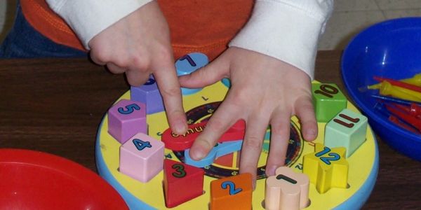 Child playing with puzzle toy at Kinder Haus