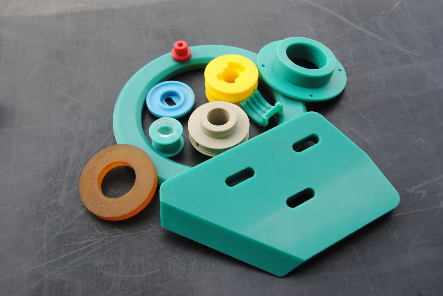 Colorful plastic mechanical parts on a dark surface.