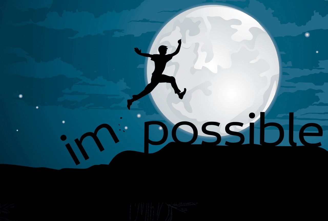 A person jumps over the word impossible A person jumps over the word impossible