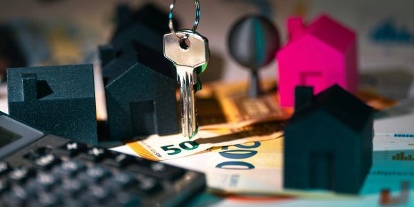 House models, keys, and euro bills symbolize real estate investment.