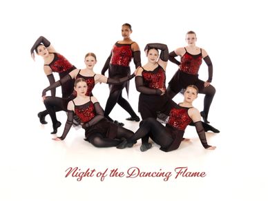 Seven dancers in red and black costumes pose together for a group photo.