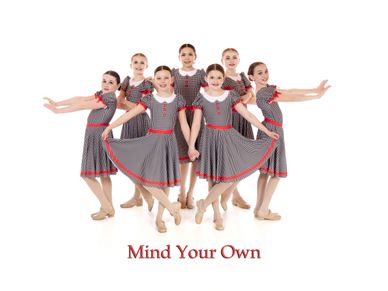 Group of young girls in matching dresses posing with 'Mind Your Own' text.