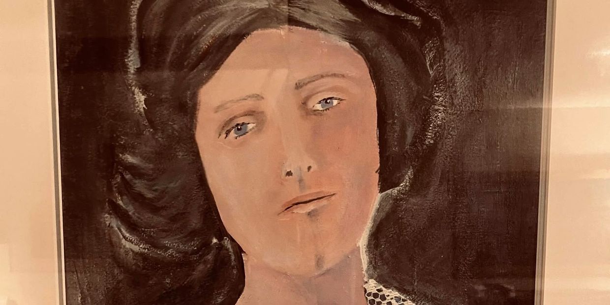 A close-up portrait of a woman with soft features and muted colors.