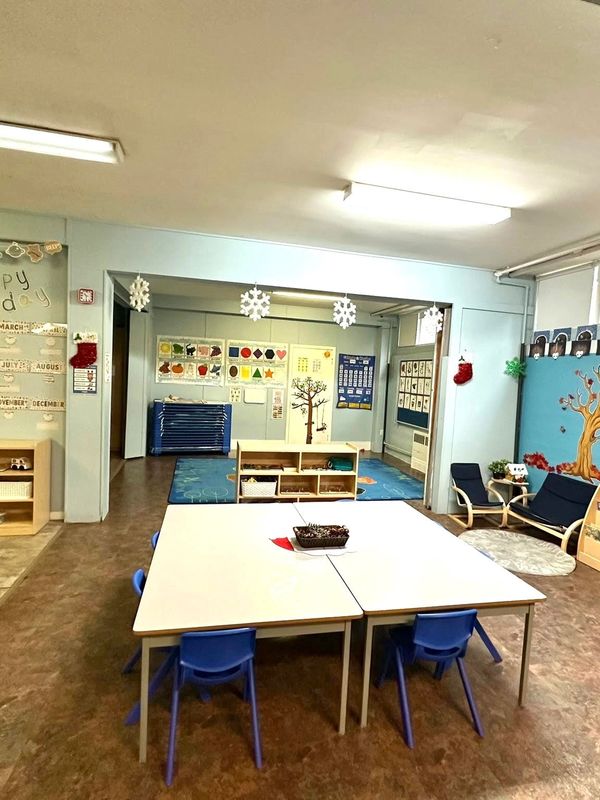 A table and chairs in the center of an early learning room.