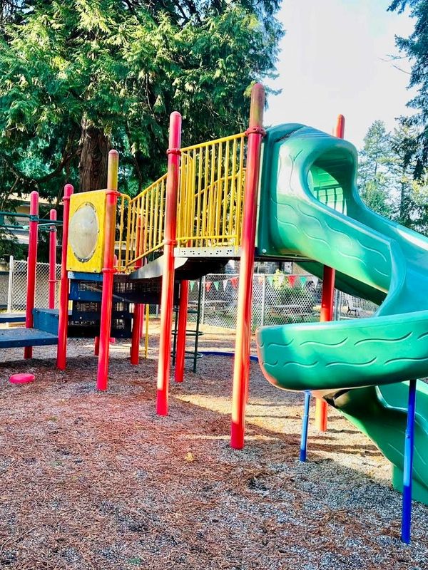 An outdoor children's playground with slide and walkways.