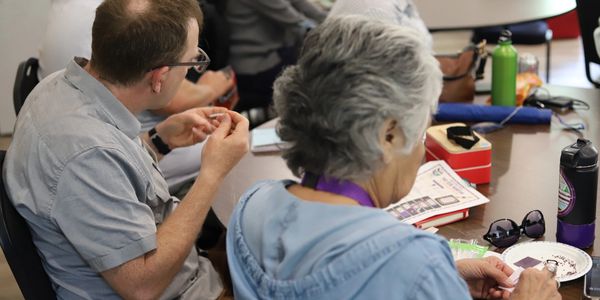 Two seniors engaged in arts and crafts at a table.