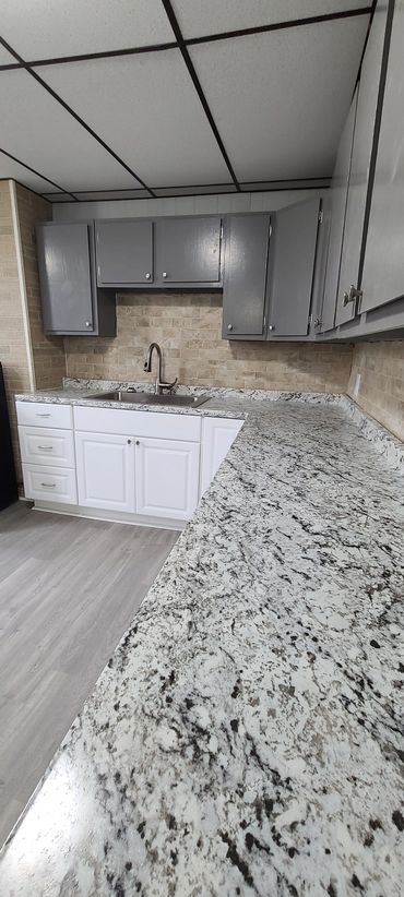Modern kitchen with granite countertops and two-tone cabinets.