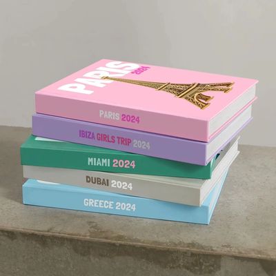 Libros de viajes apilados con destinos y años.