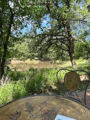 A peaceful outdoor seating area surrounded by lush greenery and trees.
