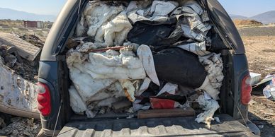 Truck bed filled with discarded foam and fabric materials.