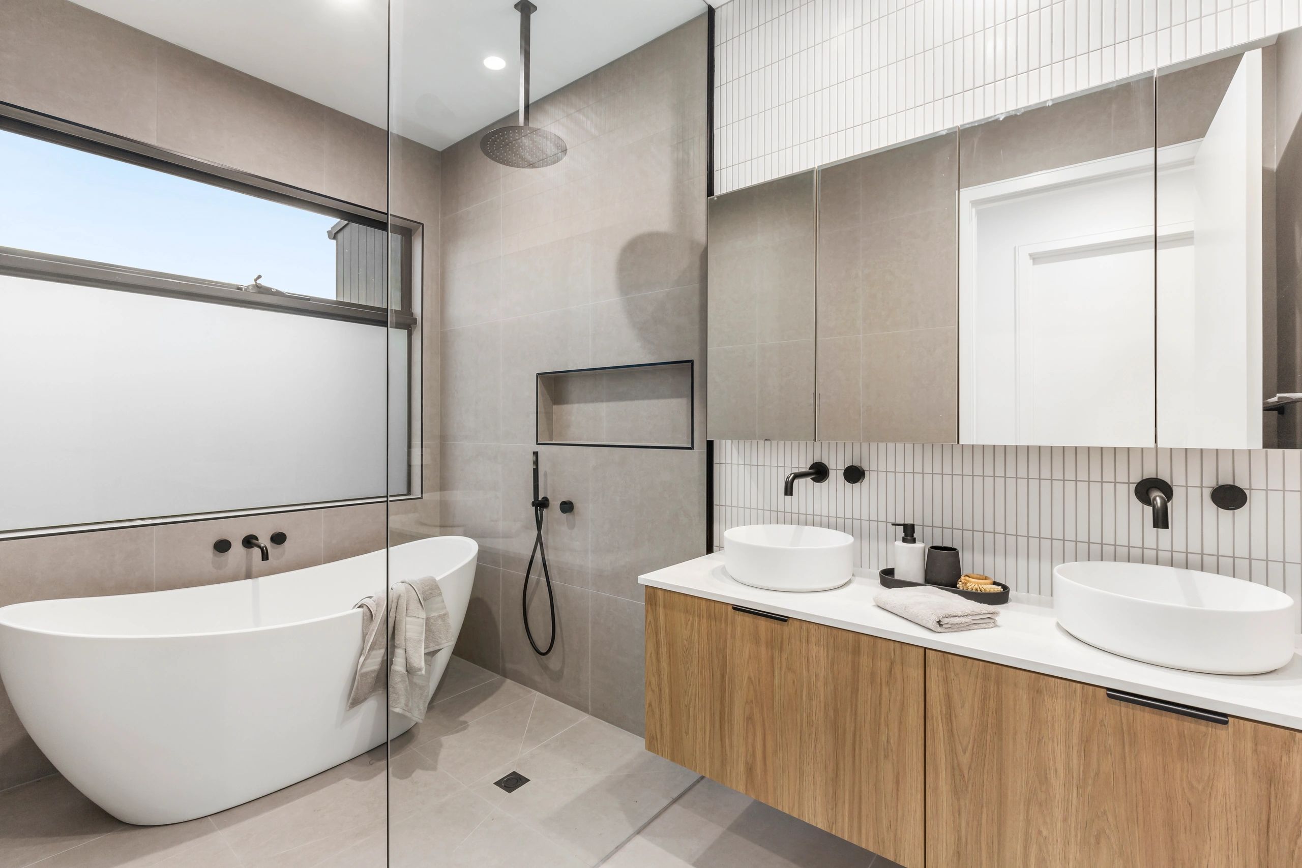 Modern bathroom with freestanding bathtub and double sinks.