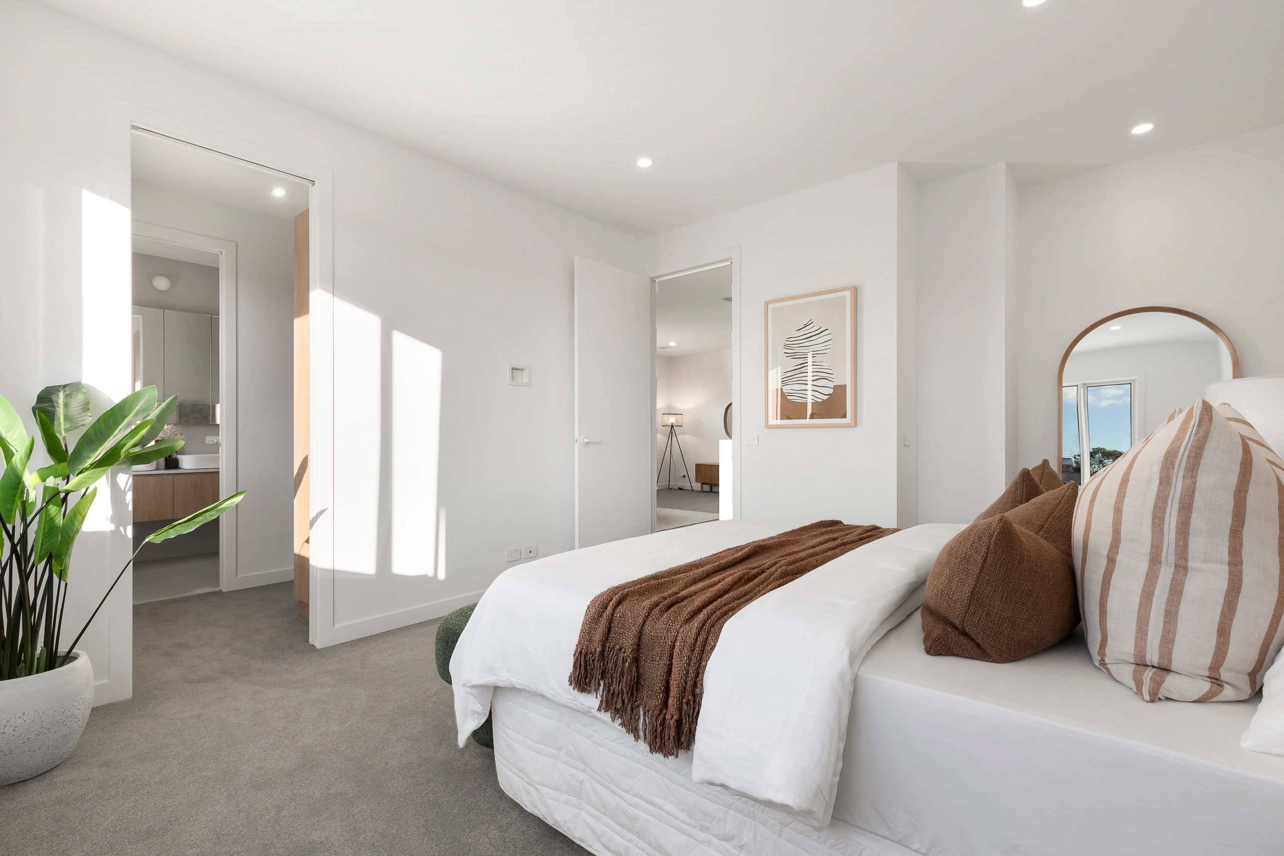 Minimalist bedroom with white walls and brown accents.