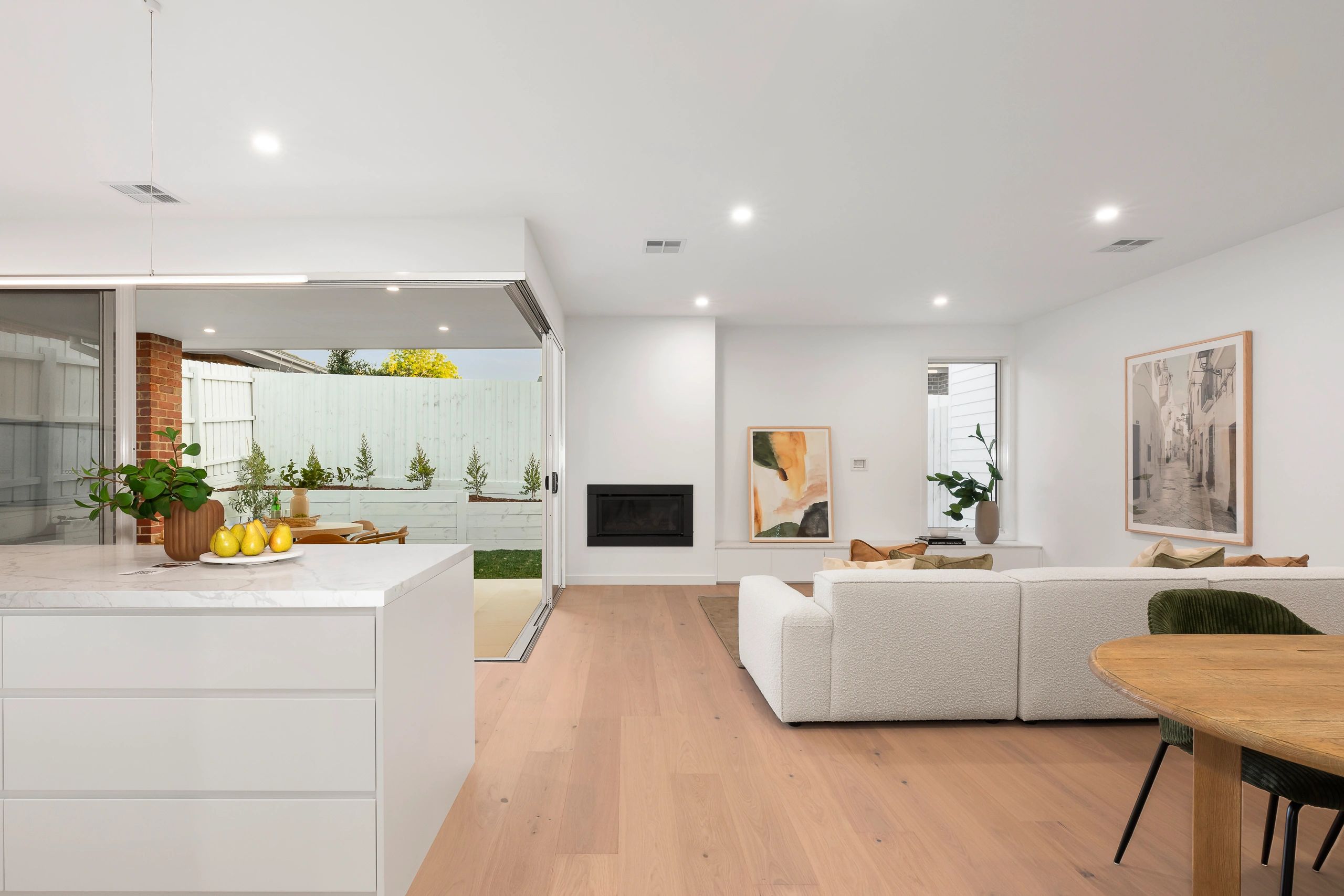 Bright modern living room with white sofa and kitchen island.