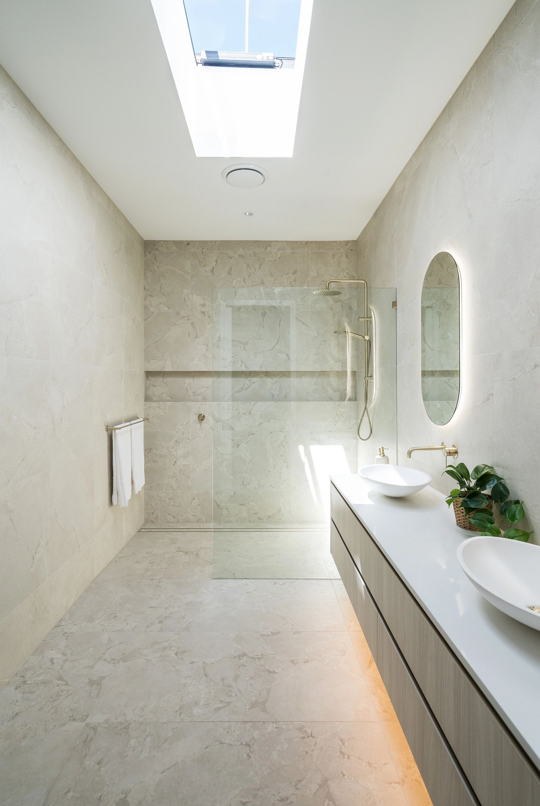 Minimalist bathroom with skylight and glass shower.