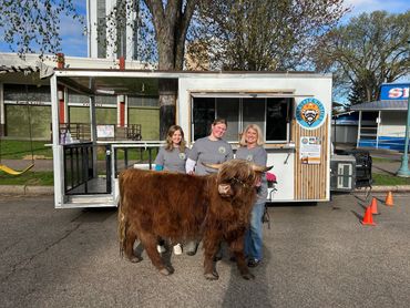 Three women standing with a big Hartnett.