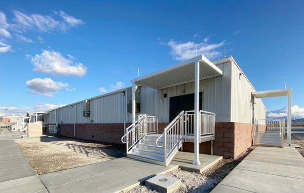 A modular building with metal stairs and clear blue sky.