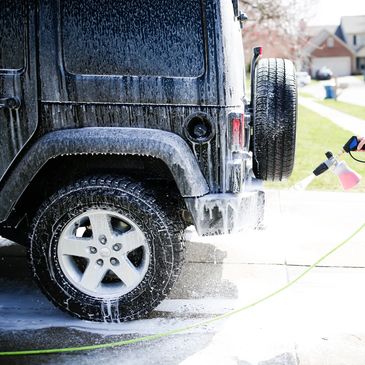 Carl spraying cleaner on Jeep Wrangler exterior detail hand wash detail.