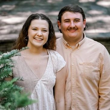 Ms. Katie - a white woman with brown hair- and her husband clay- a white man with brown hair - pose  