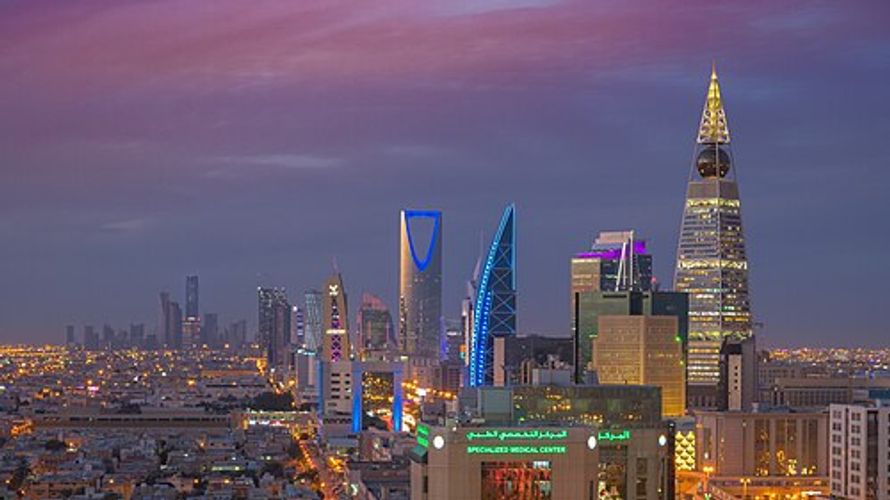 Riyadh city skyline at dusk with illuminated skyscrapers and a purple sky, Kingdom of Saudi Arabia.