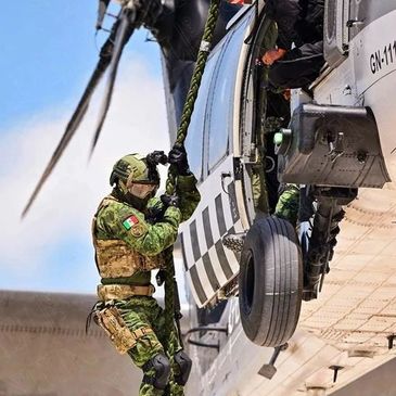 Adiestramiento de Fuerzas Especiales, militar descendiendo en soga rápida desde un helicóptero.