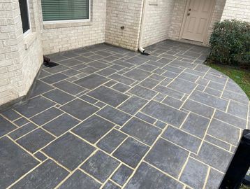 Newly paved outdoor patio with dark tiles and light grout lines.