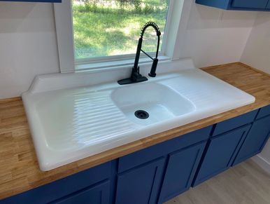 Refurbished 1890s farmhouse kitchen with new sink and cabinet installation in Huntsville, Texas