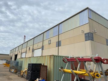 Industrial building with storage containers outside.