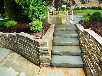 Stone steps with stone retaining walls and landscaping.