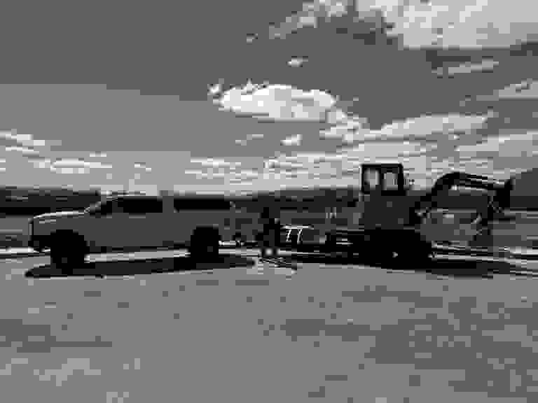 Stack of books next to pencils in a holder and a camera.