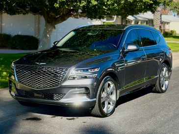 A sleek black luxury SUV parked on a suburban street.