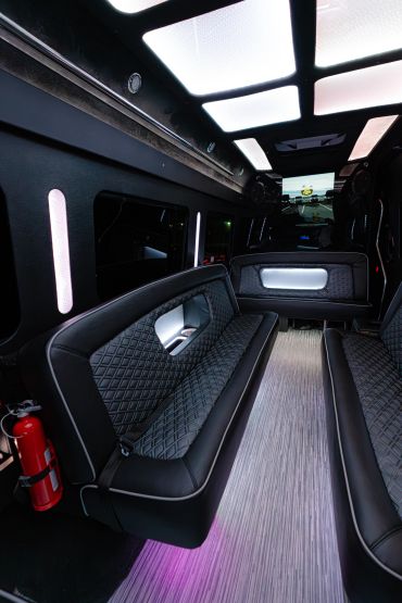 Luxurious black leather seating inside a modern limousine with ambient lighting.