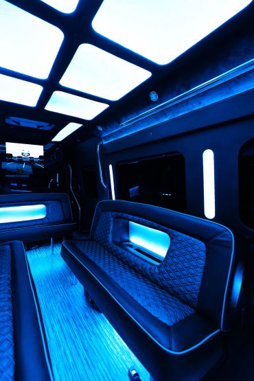 Luxurious limousine interior with blue LED lighting and quilted leather seats.