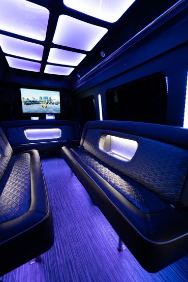 Luxurious limousine interior with blue ambient lighting and spacious seating.