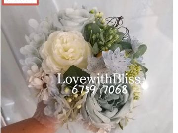手捧一束白色及浅绿色花束。