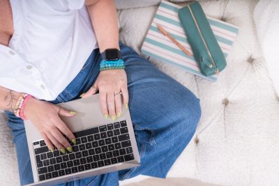 Person using a laptop while sitting cross-legged.