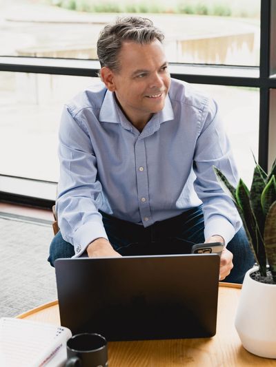 Dan Parsons sat with a laptop - Leadership Coaching, Enhancing Communication and Strategic Alignment