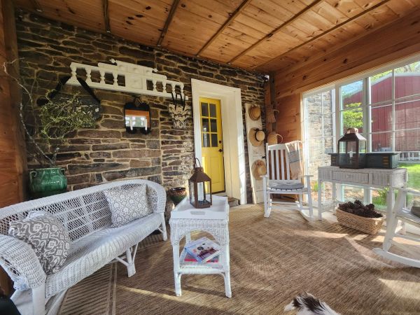 Cozy sunroom with wicker furniture and stone accent wall.