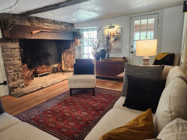 Cozy living room with stone fireplace and neutral furniture.