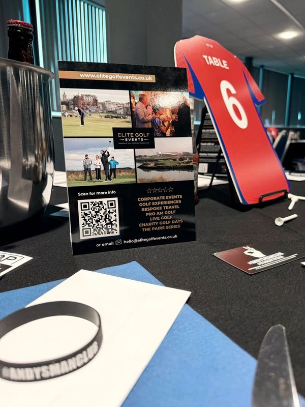 Table setup with Elite Golf Events flyer and Table 6 marker in a meeting room.