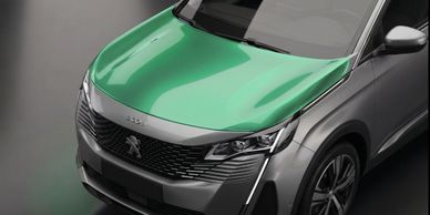 Sleek silver Peugeot SUV with a striking green hood on display.