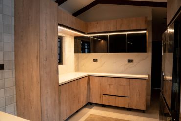 Modern kitchen with wood-finish cabinets and ambient lighting.