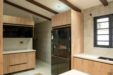 Modern kitchen with wooden cabinets and black appliances.