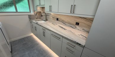 Sleek modern kitchen with marble countertop and under-cabinet lighting.