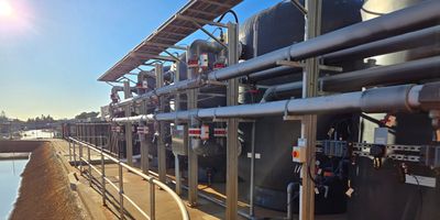 Industrial piping and tanks under clear sky.
